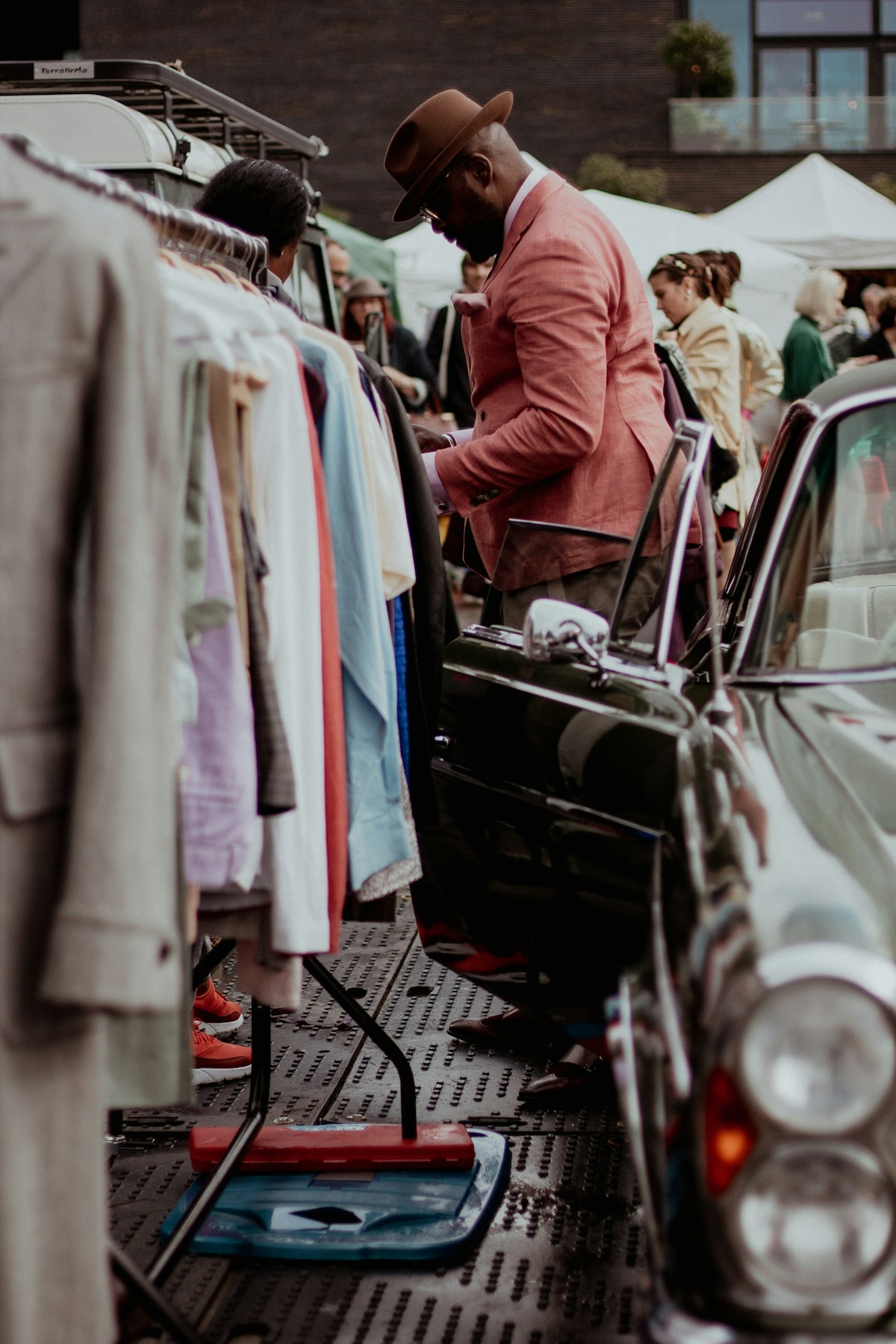a man standing next to a car in a parking lot