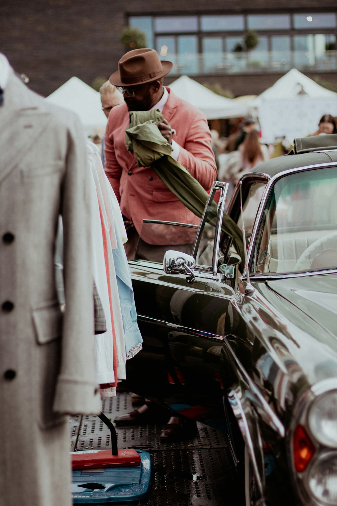 a man standing next to a car in a parking lot