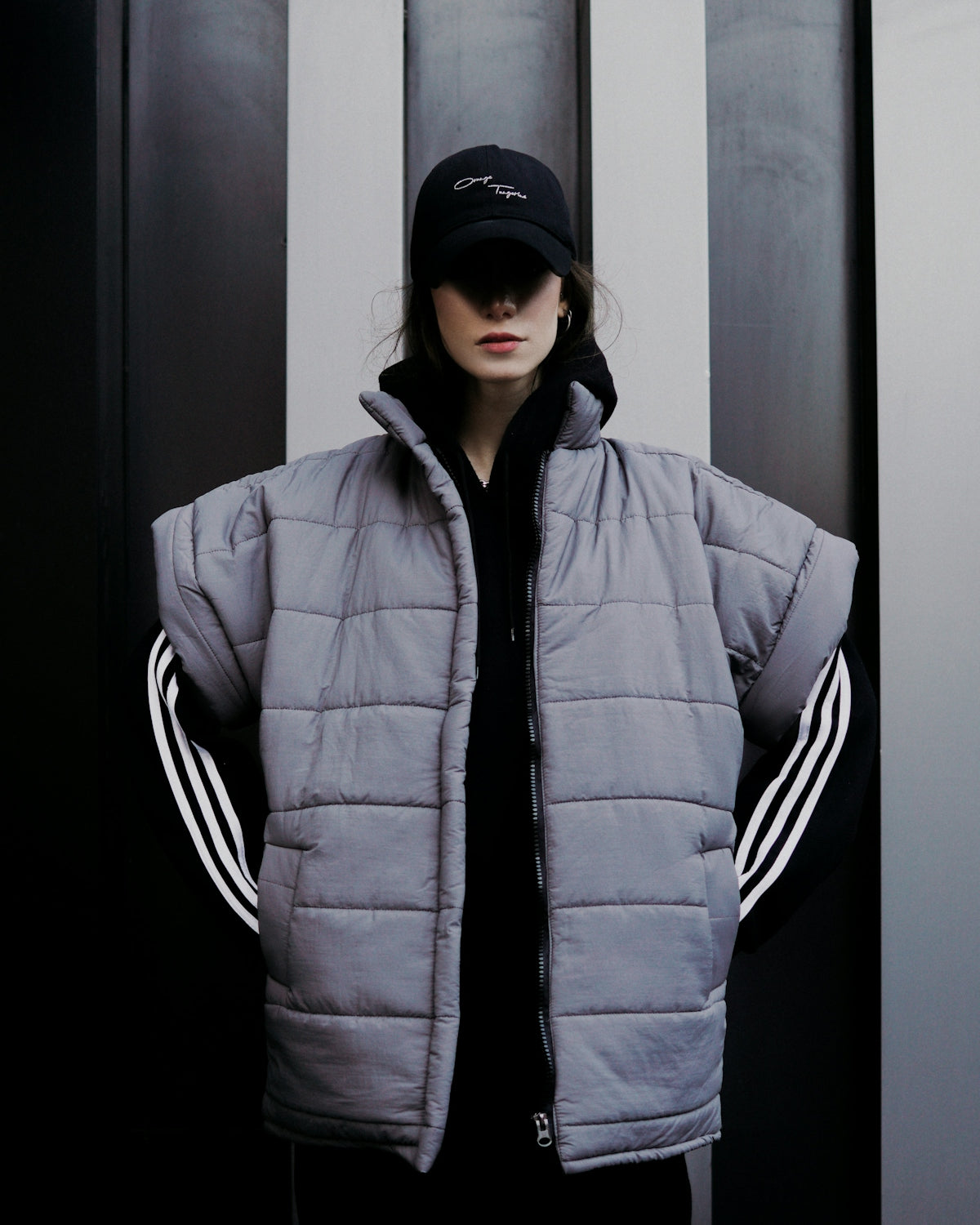 a woman standing in front of a black and white wall