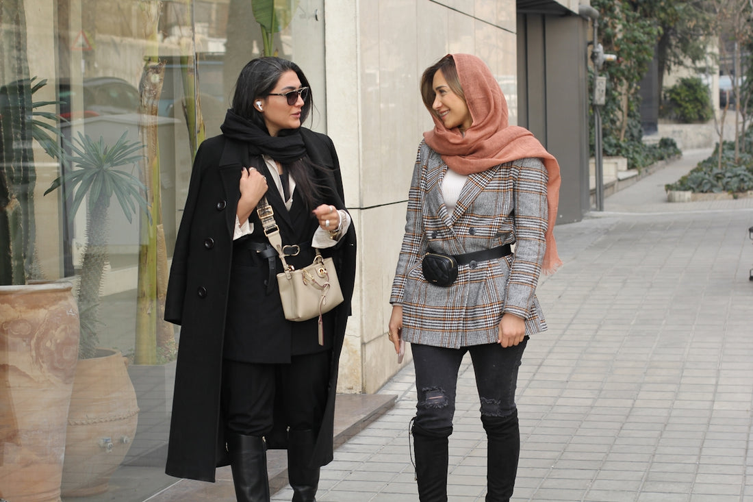 two women walking down a sidewalk next to each other