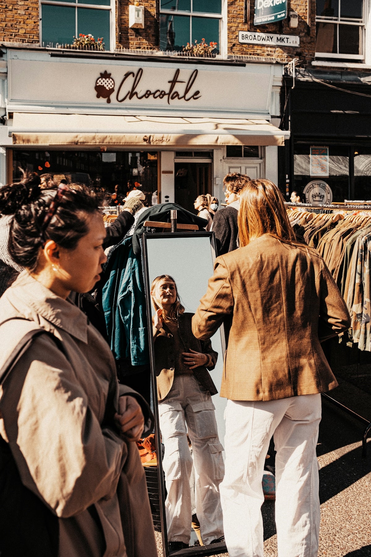 a group of people standing outside of a clothing store