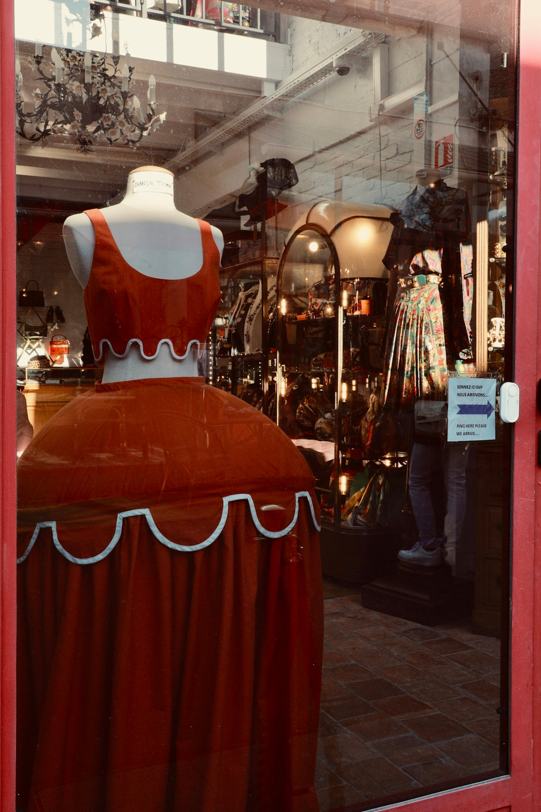 a mannequin dressed in a red dress in a shop window