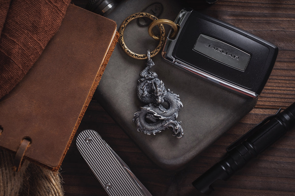 a dragon keychain sitting on top of a table next to a wallet