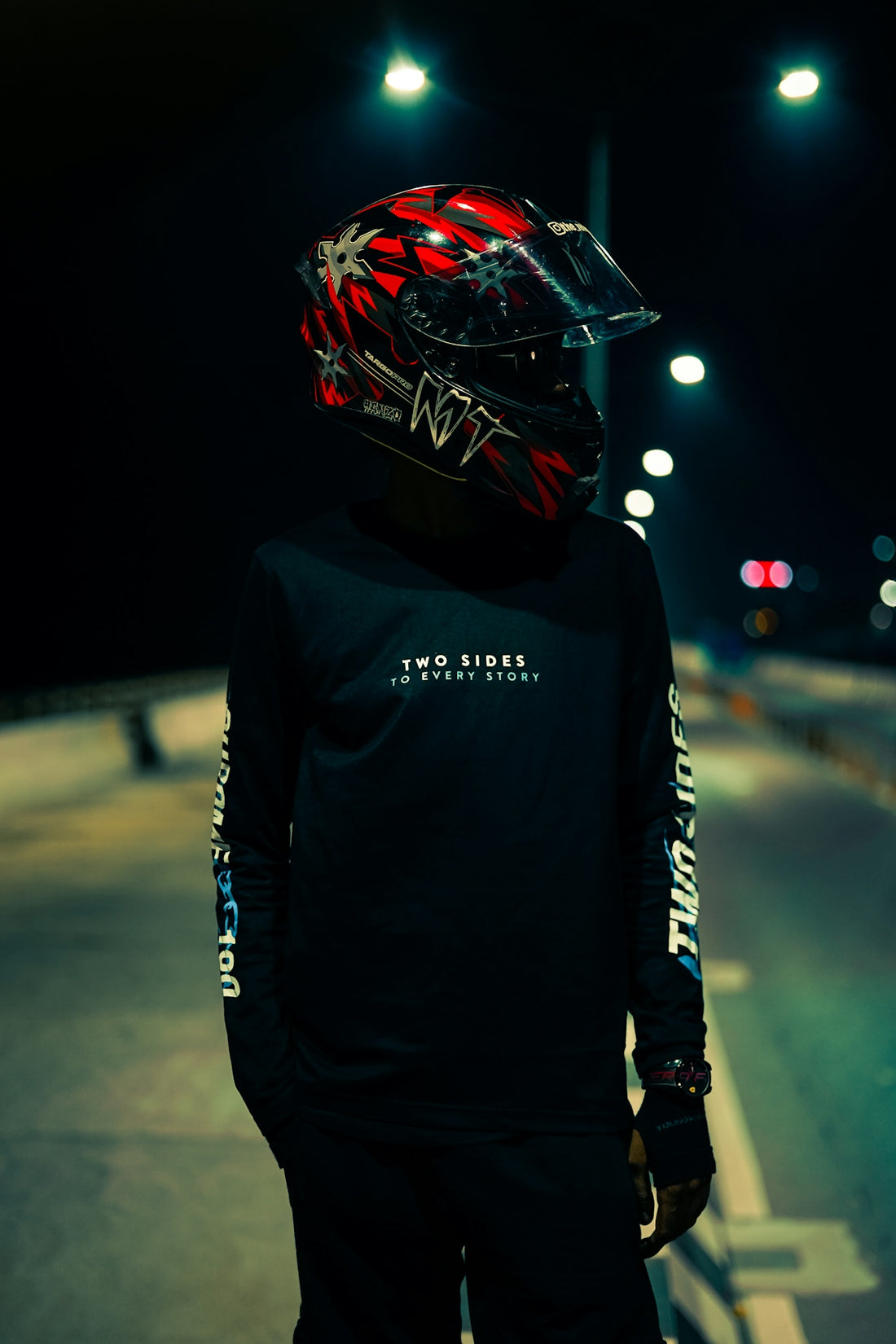 a person wearing a helmet standing on the side of a road