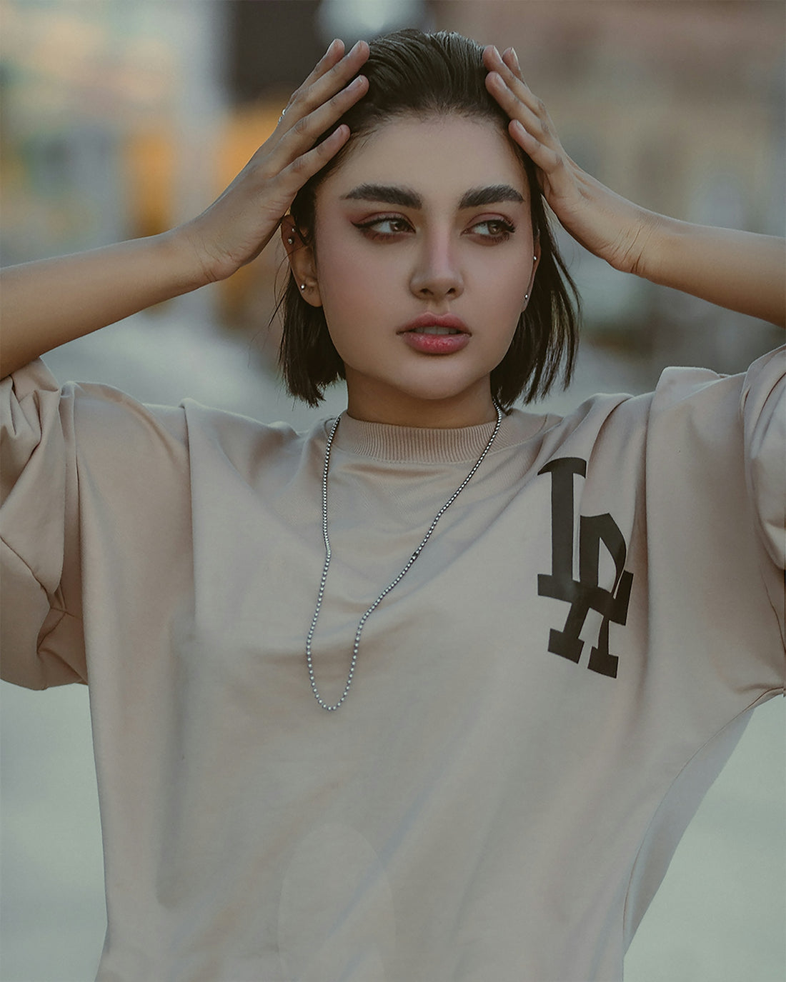 a young woman is holding her hands to her head