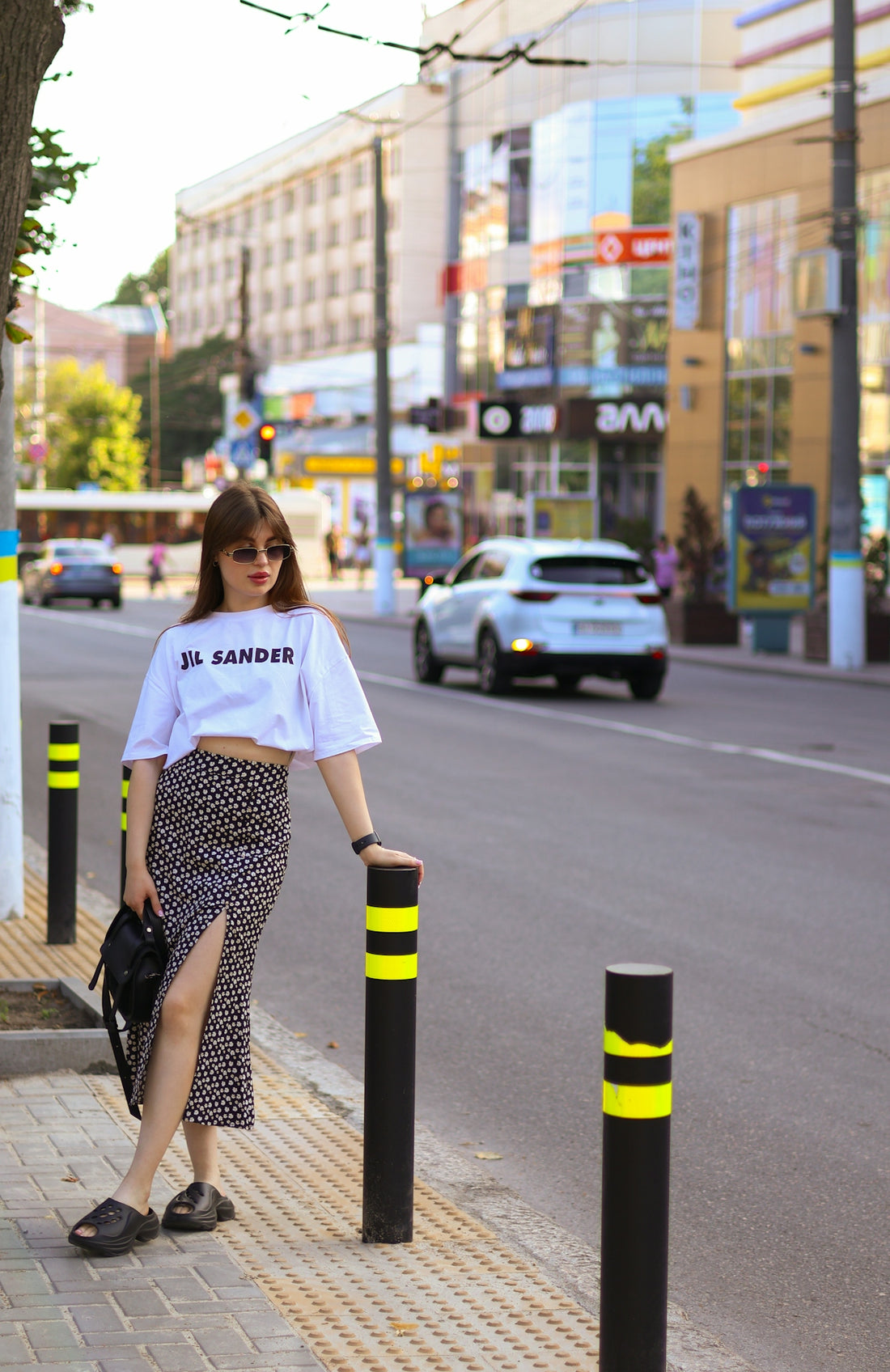 a woman standing on the side of a street