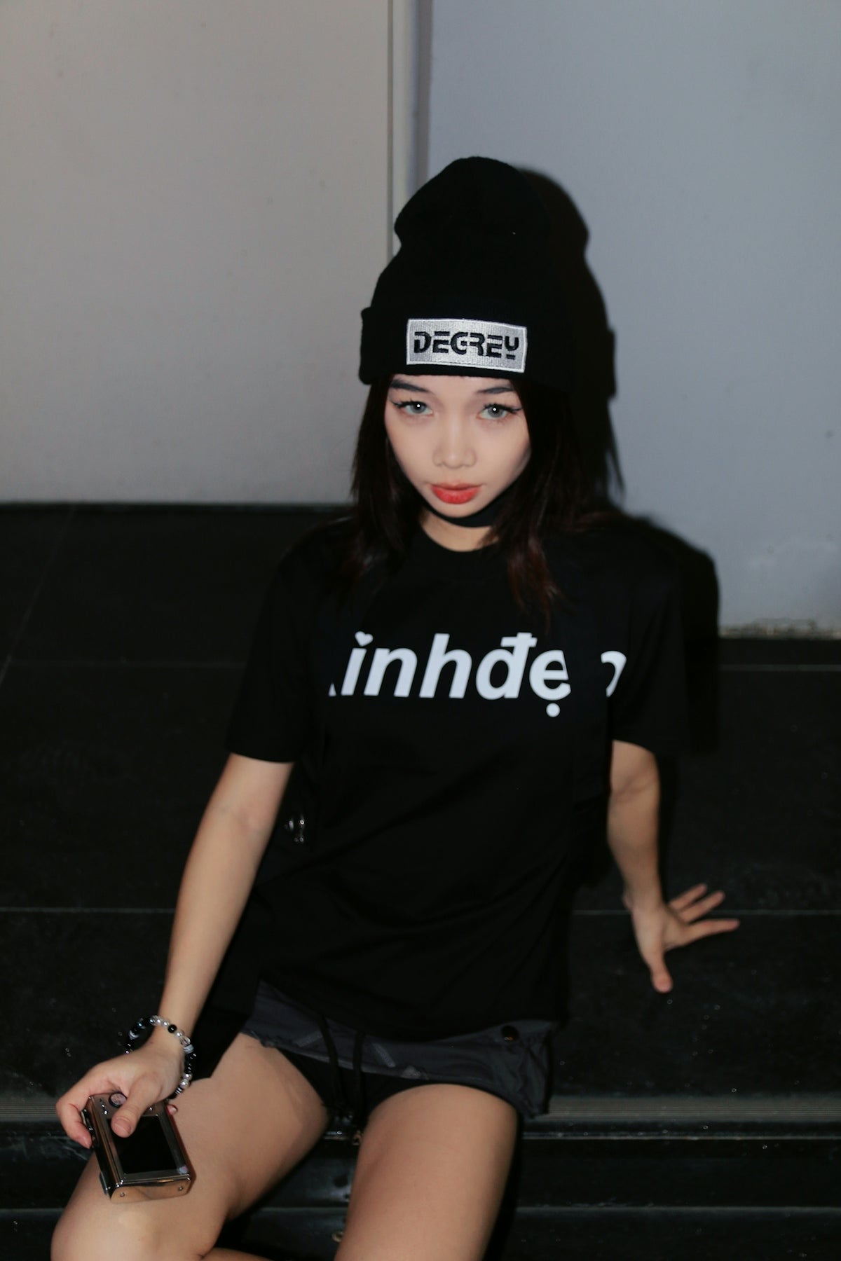 a woman sitting on the steps wearing a hat