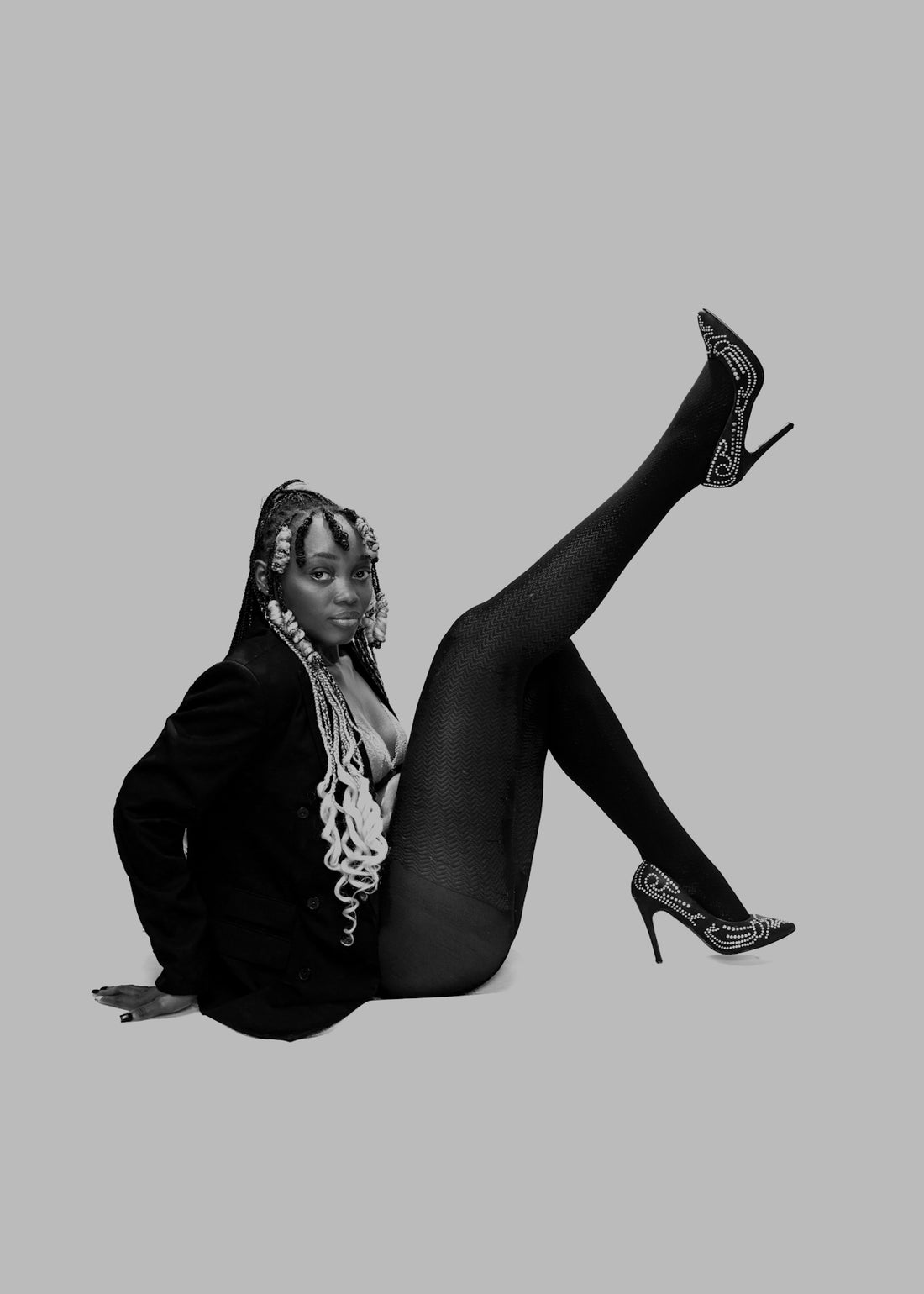 a woman in high heels is sitting on the floor