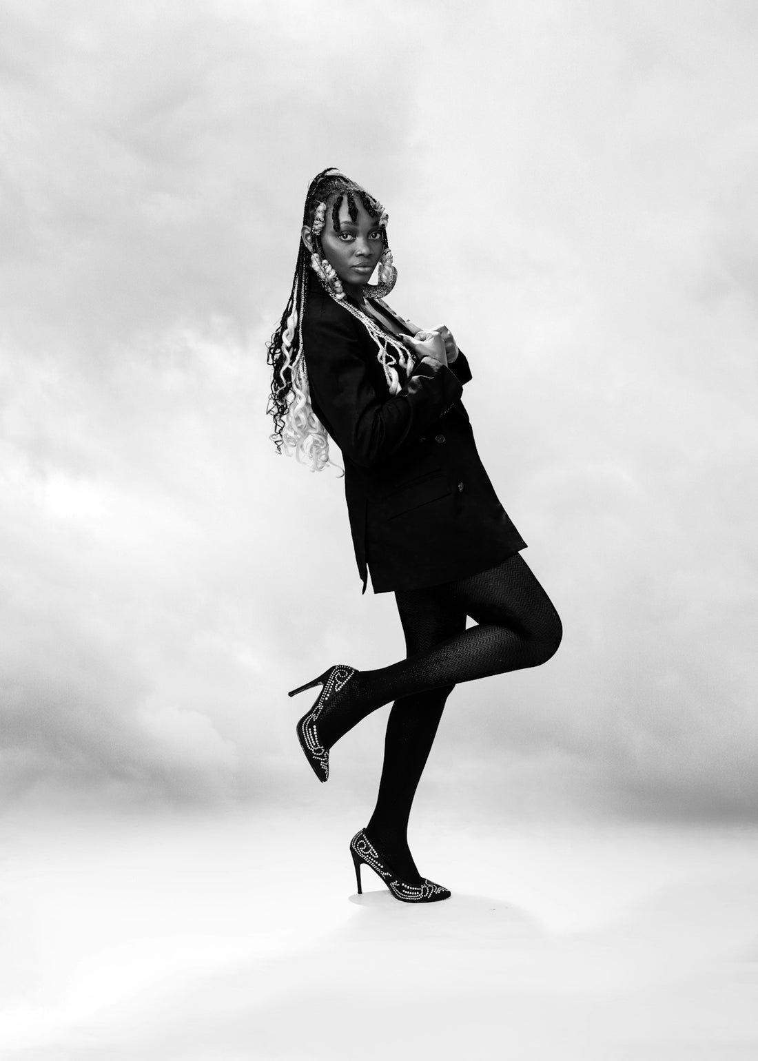 a woman in a suit and scarf is posing for a picture