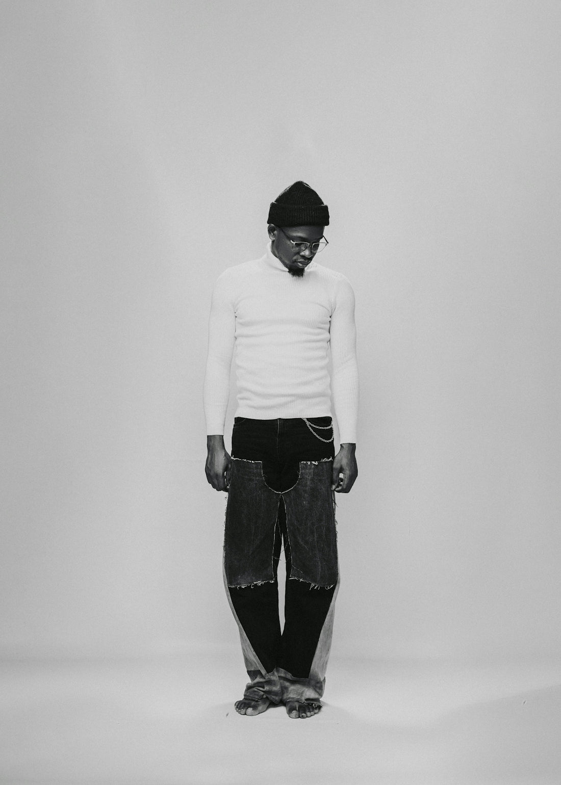 a black and white photo of a man wearing a hat