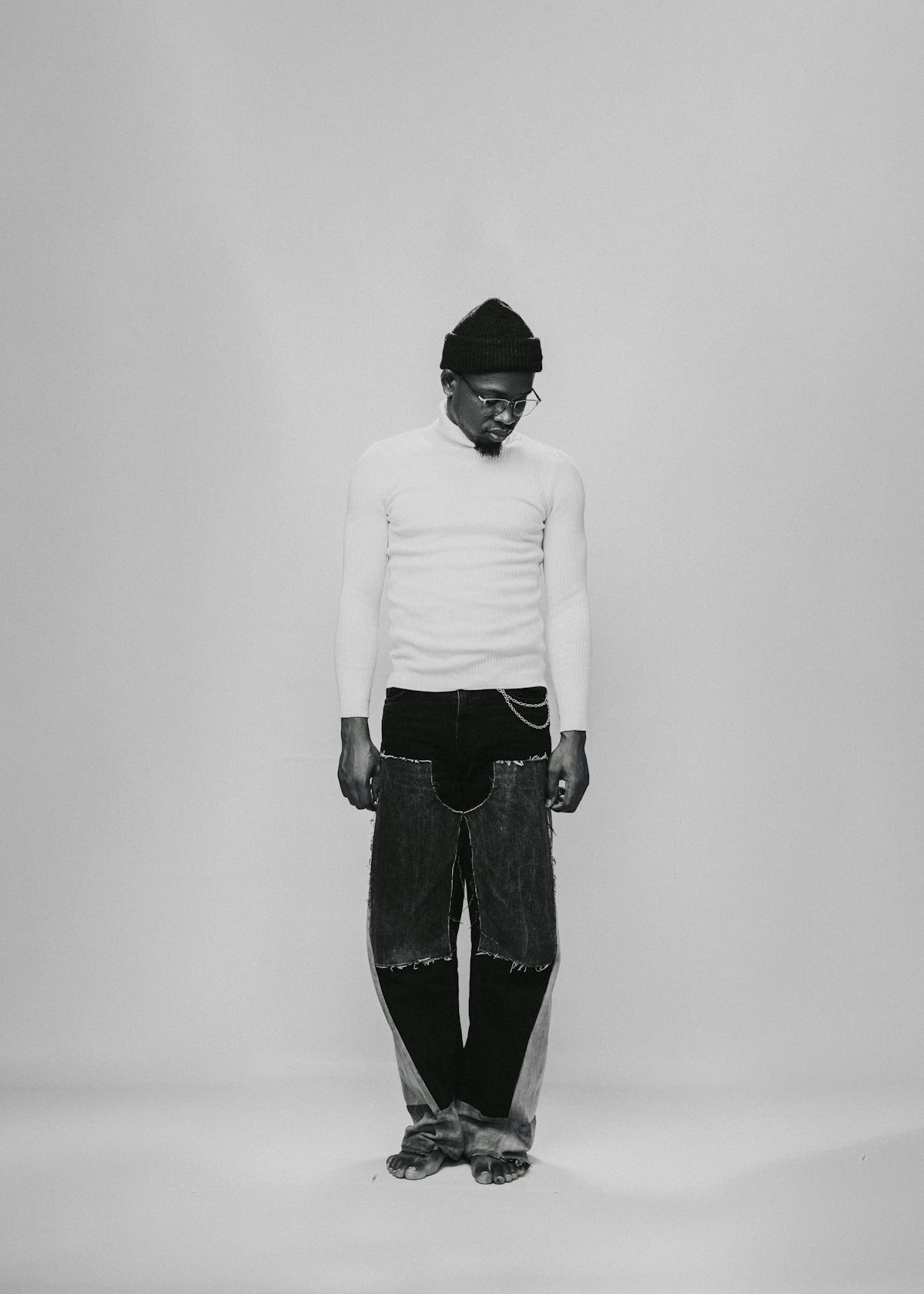 a black and white photo of a man wearing a hat