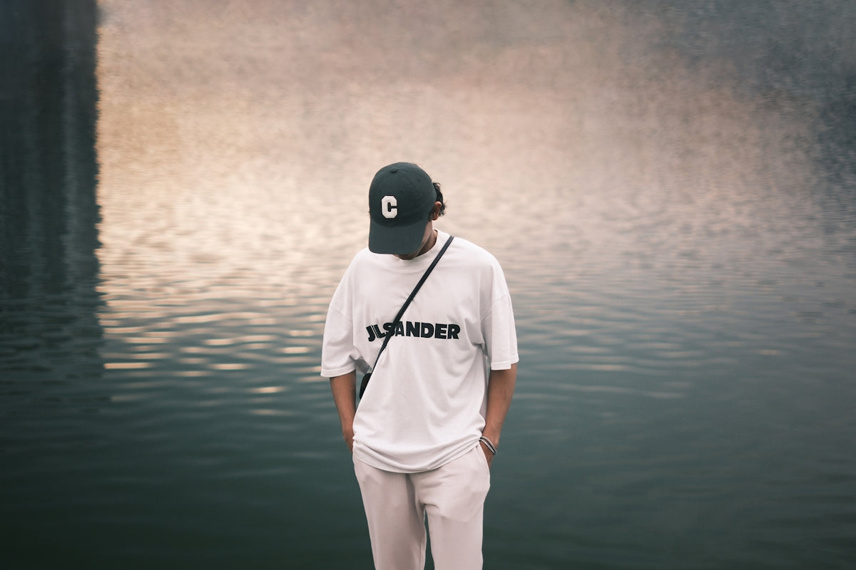 a man standing on a dock next to a body of water