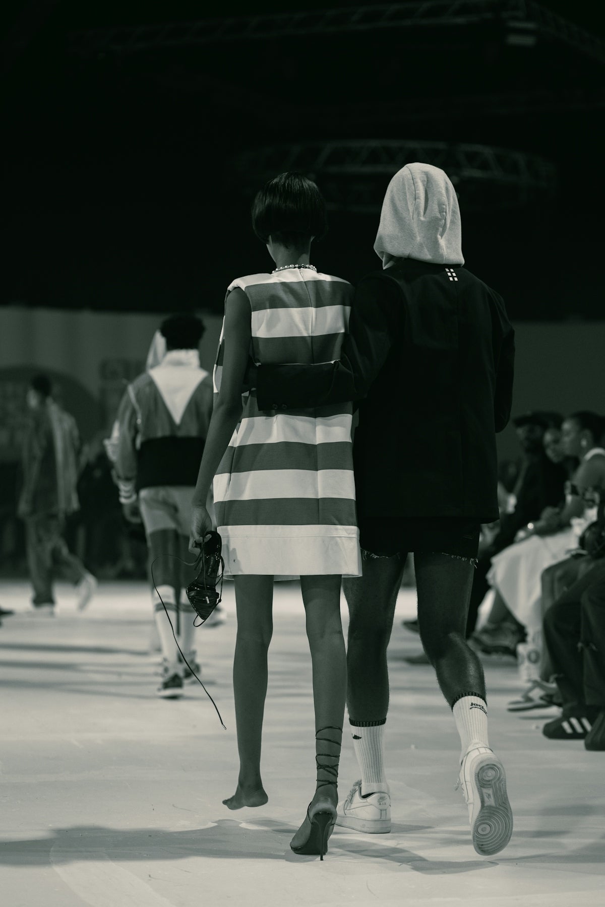 A couple of people walking down a runway