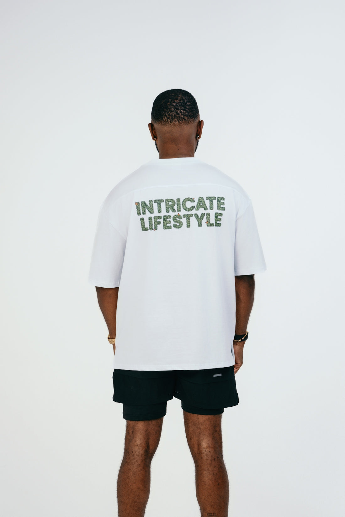 A man wearing a white t - shirt with green lettering