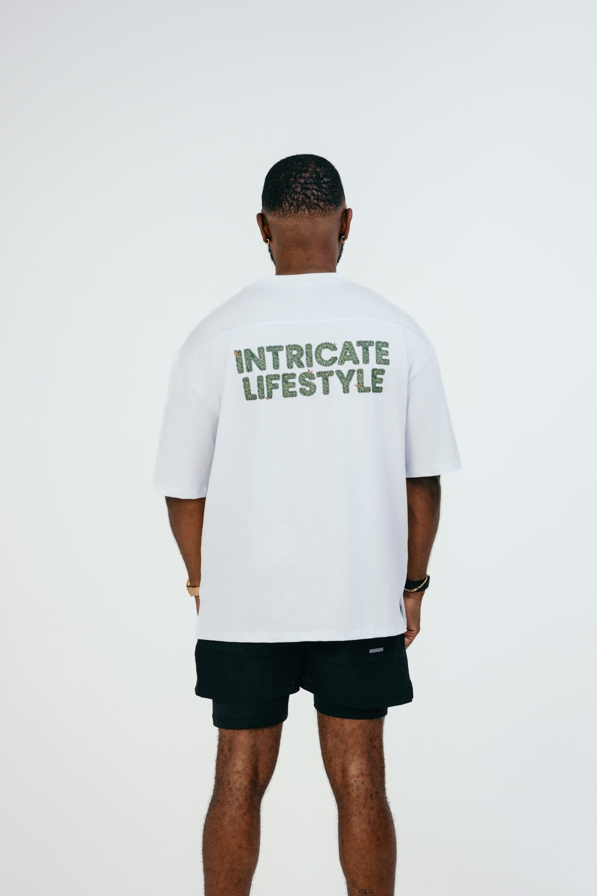 A man wearing a white t - shirt with green lettering