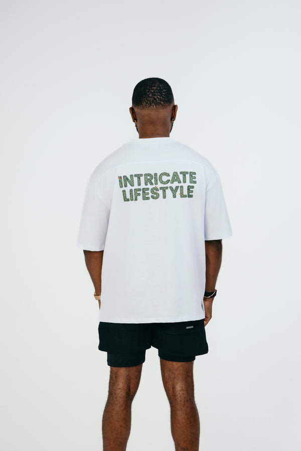 A man wearing a white t - shirt with green lettering