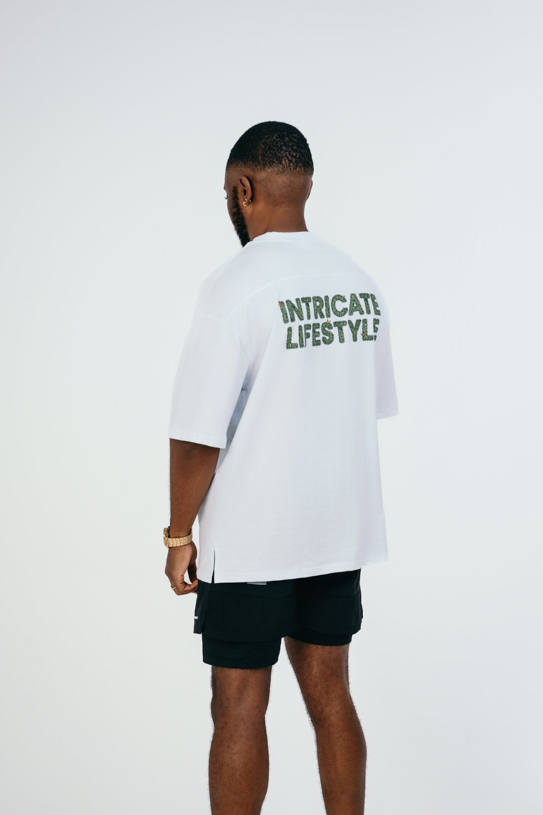 A man in a white shirt and black shorts