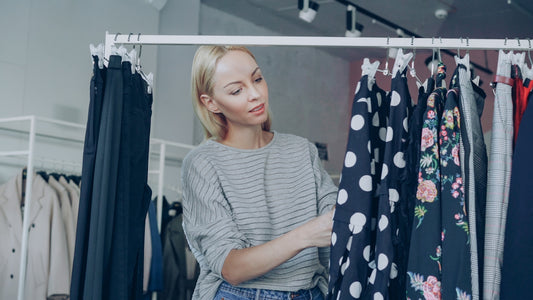 Woman browses clothes on a rack in a store.