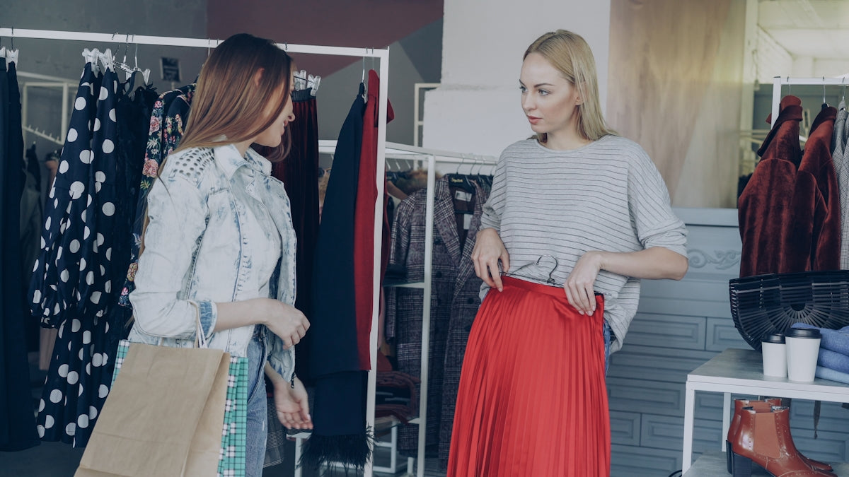 Two women try on clothes in a boutique.
