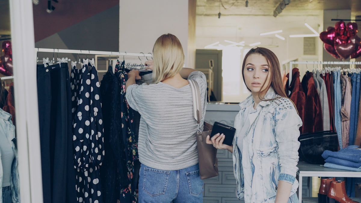 Two women are shopping for clothes in a boutique.