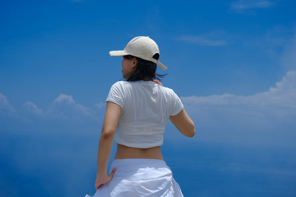 Woman in white layered summer outfit against blue sky — Fashionfitz UK fashion 2026