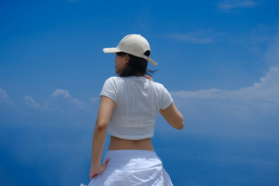 Woman in white layered summer outfit against blue sky — Fashionfitz UK fashion 2026