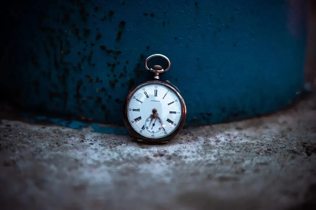 Vintage pocket watch resting on a textured surface, showcasing its face and adjustable LBDS feature