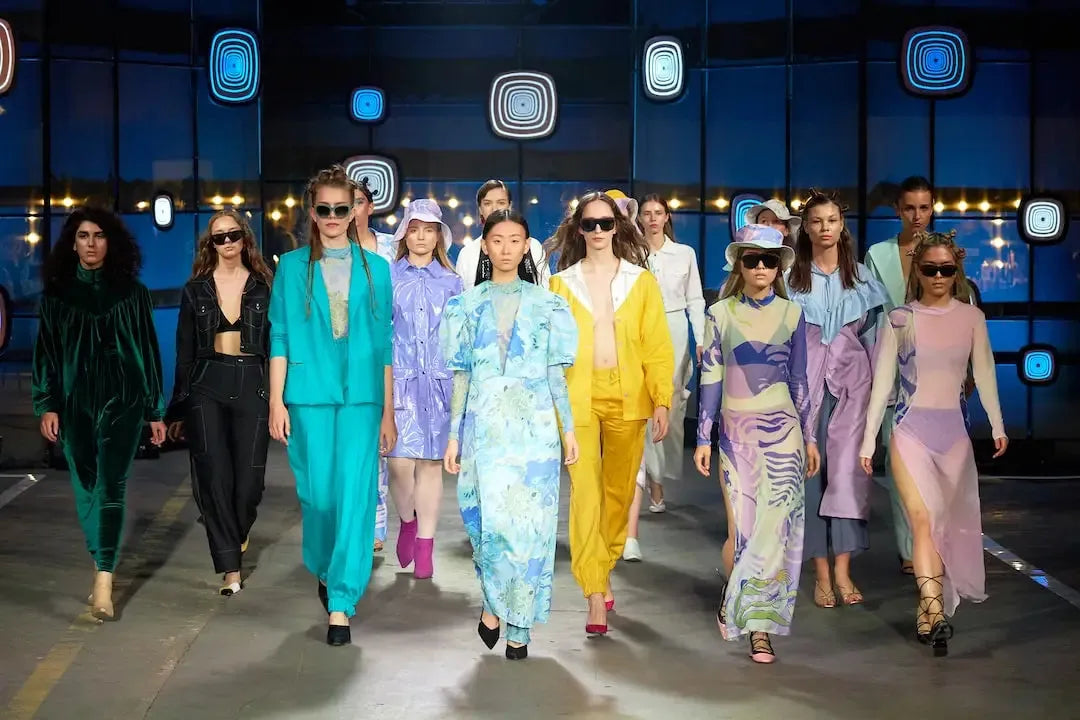 Fashion runway featuring models in stylish outfits, including split hem jeans and vibrant ensembles