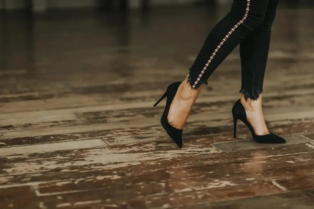 Stylish streetwear revolution featuring high-heeled shoes paired with ripped black jeans on wooden floor