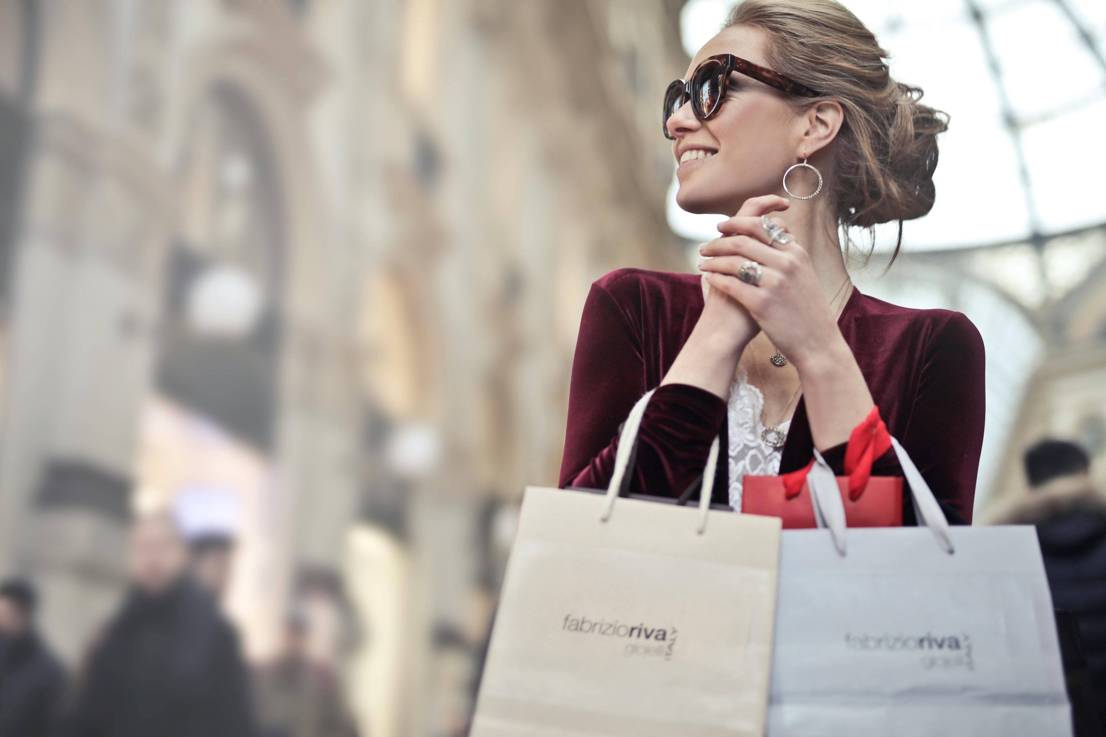 Happy woman shopping with bags during the Fashion Sale in a stylish setting