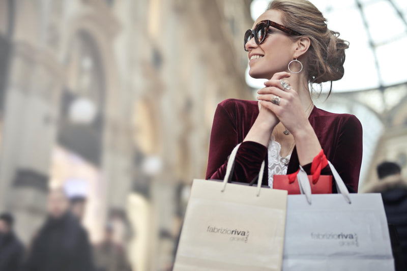 Happy woman shopping with bags during the Fashion Sale in a stylish setting