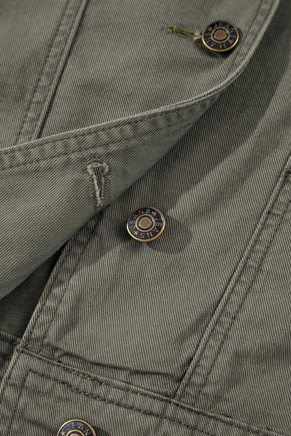 Close-up of button and stitching on Green Bay Ruffled Denim Vest - Women's Fashion Trends highlighting quality craftsmanship and western style.