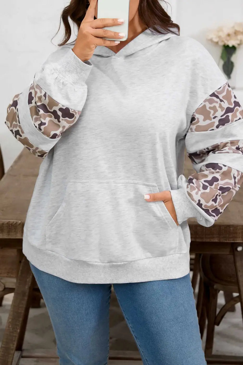 Close-up of Curve Light Grey Camo Panel Hoodie for Women highlighting camo sleeve details and cozy front pocket in a plus size fit.