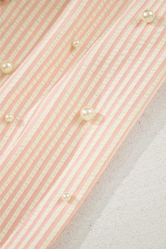 Close-up of pearl embellishments on the striped sleeve of the Bow Cuff Blouse, adding a delicate, whimsical touch.