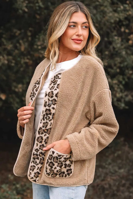 Side angle of women’s plush leopard print jacket with cozy fleece fabric and bold animal print accents on front and pockets.
