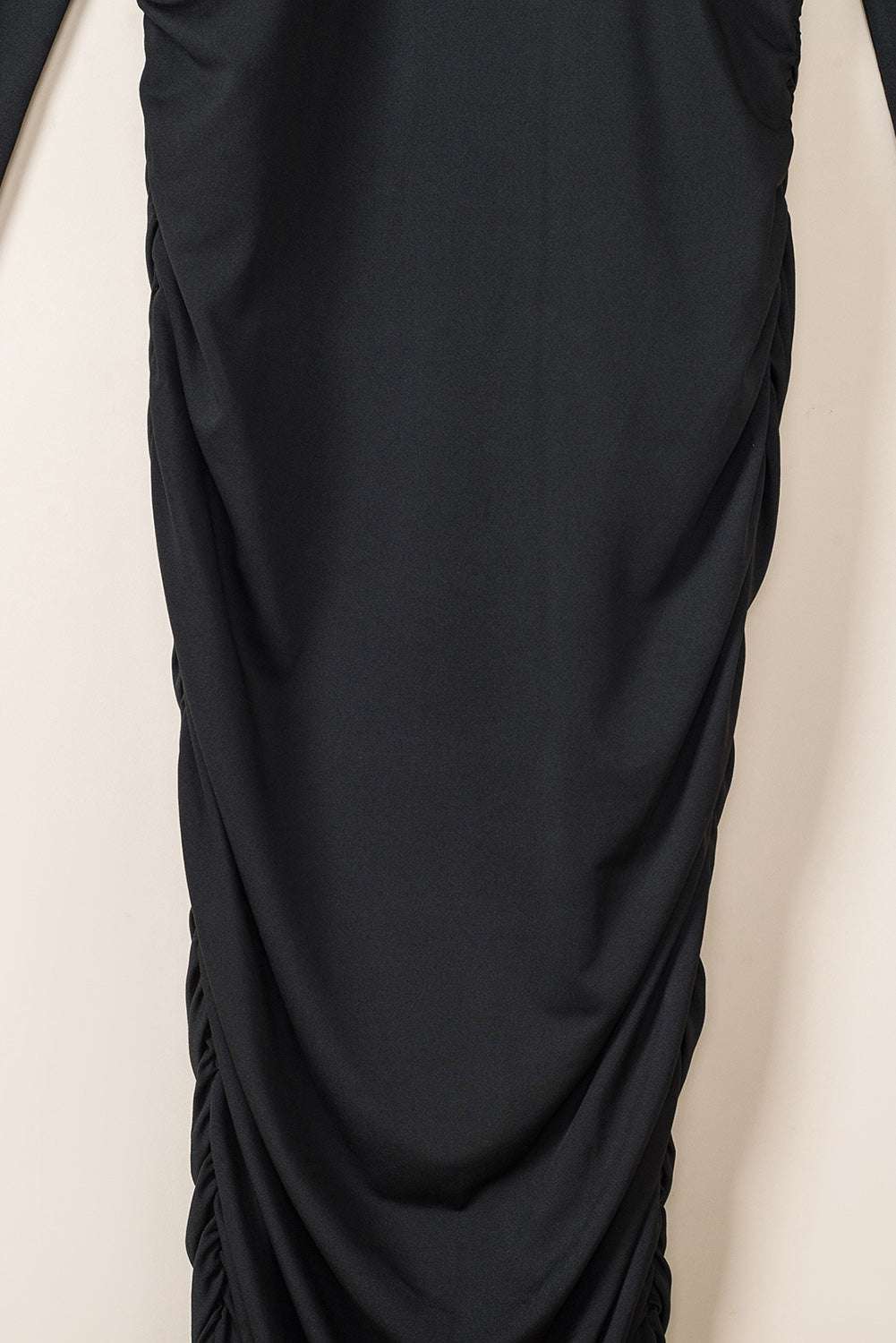 Close-up of ruched detailing on the skirt of the Ladies Black Wrap Drape Midi Dress, showcasing texture and body-contouring fit.