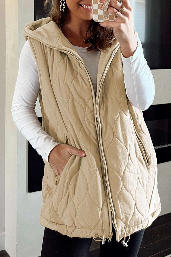 Women wearing khaki Quilted Fleece‑Lined Winter Gilet with front zipper and hood, styled over a white long-sleeve top and black leggings.