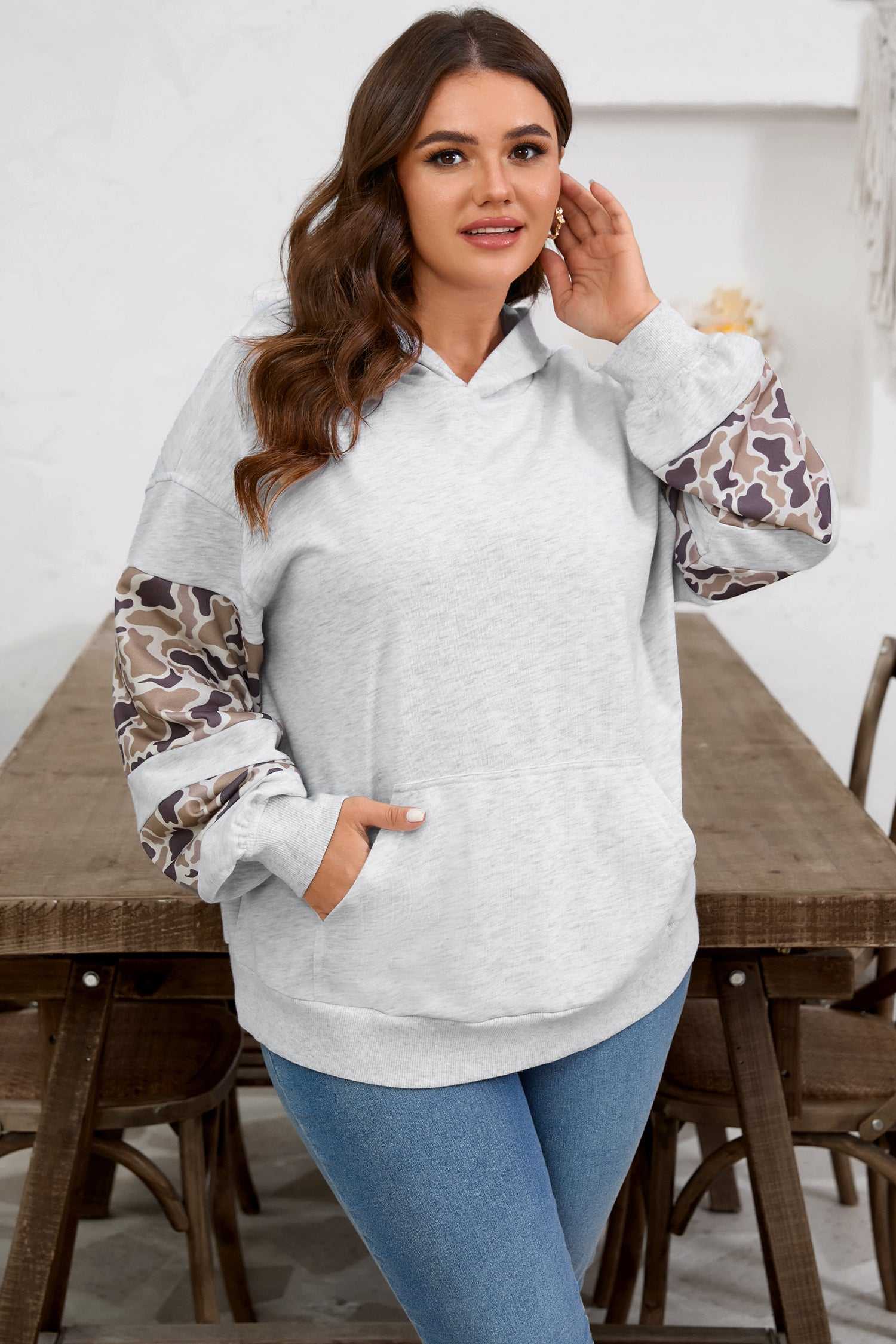 Women's Curve Light Grey Camo Panel Hoodie styled with jeans, showcasing camo patchwork sleeves and a soft relaxed fit.