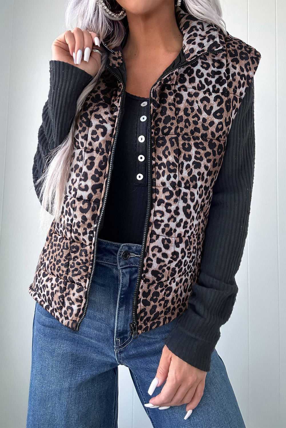 Leopard Print Quilted Puffer Gilet for women styled with black ribbed top and jeans. Sleeveless zip-up jacket ideal for fall layering.