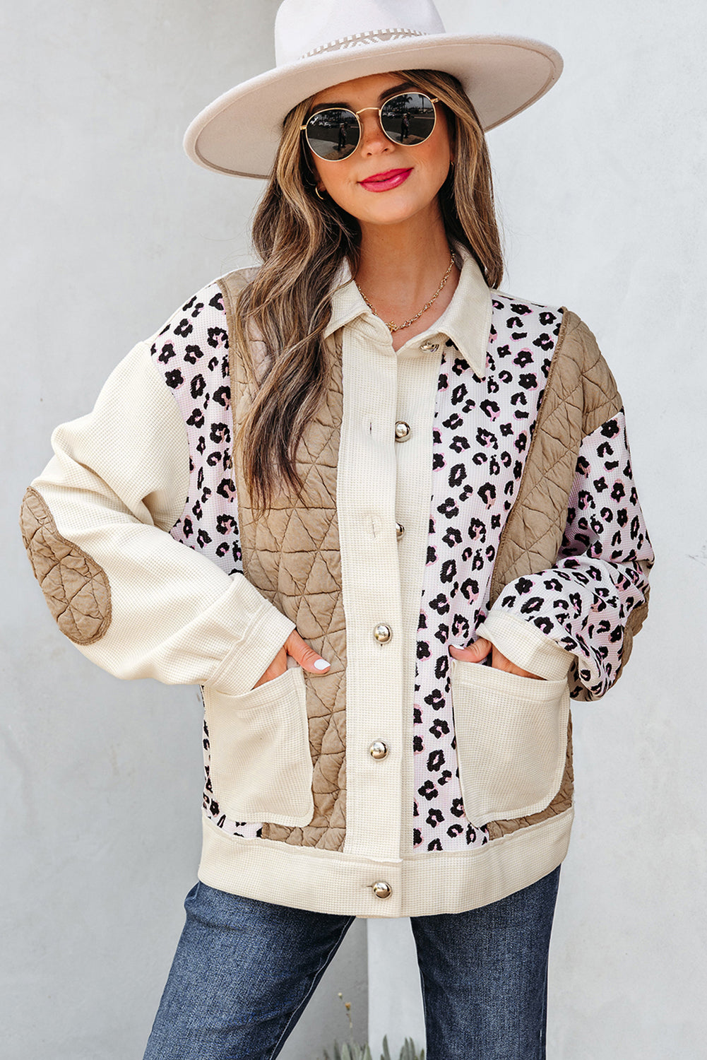 Woman wearing a leopard print and beige quilted jacket against a white background