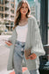 Light grey chunky knit oversized cardigan styled with casual wear, featuring puff sleeves and cozy texture.