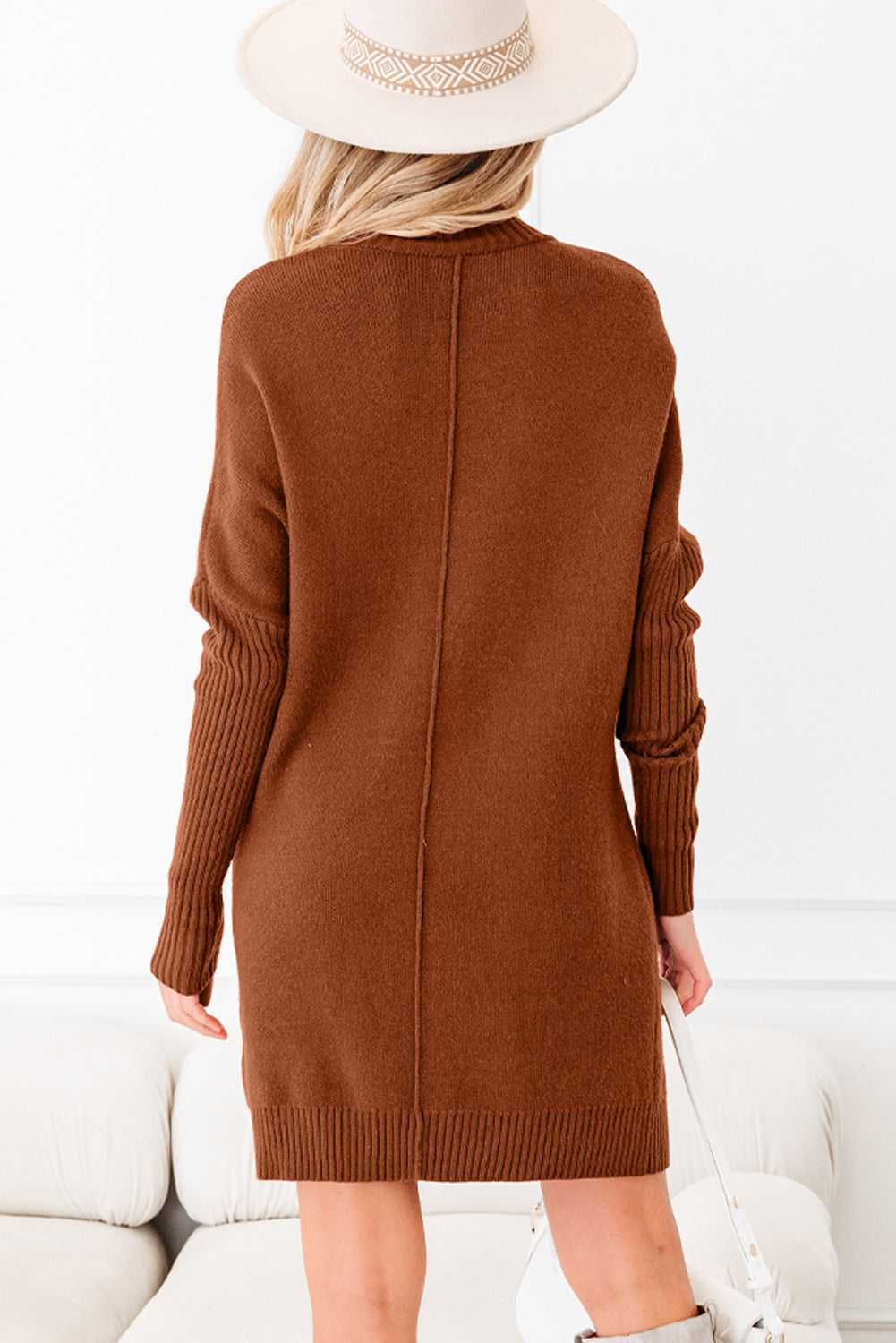 Back view of brown high neck knit jumper dress with ribbed cuffs and center seam. Modern winter dress for casual or smart-casual wear.
