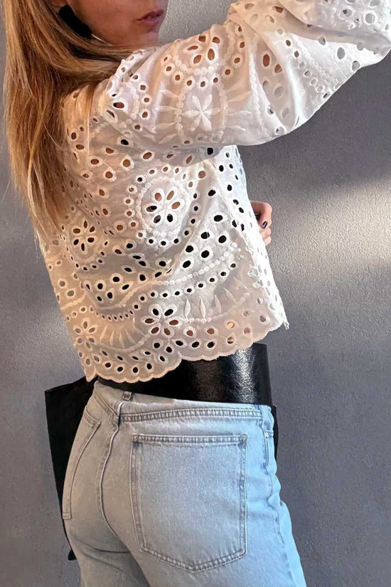 Person wearing a White Cutwork Embroidered Crop Top and light blue jeans against a plain background