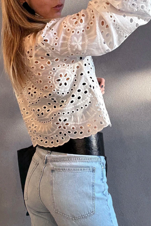 Person wearing a White Cutwork Embroidered Crop Top and light blue jeans against a plain background
