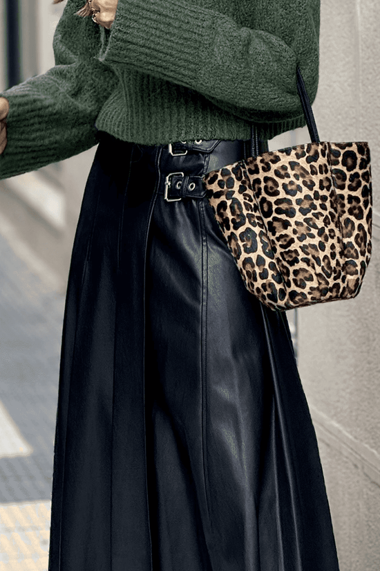 Black Faux Leather Pleated Flared Skirt | FashionFitz paired with leopard print bag, emphasizing the high-waist buckle detail and sleek PU leather finish.