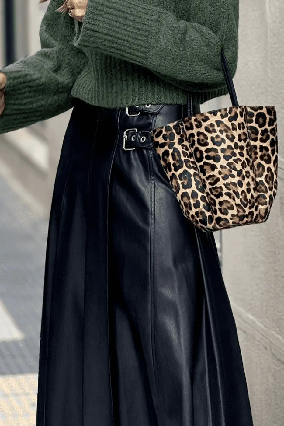 Black Faux Leather Pleated Flared Skirt | FashionFitz paired with leopard print bag, emphasizing the high-waist buckle detail and sleek PU leather finish.