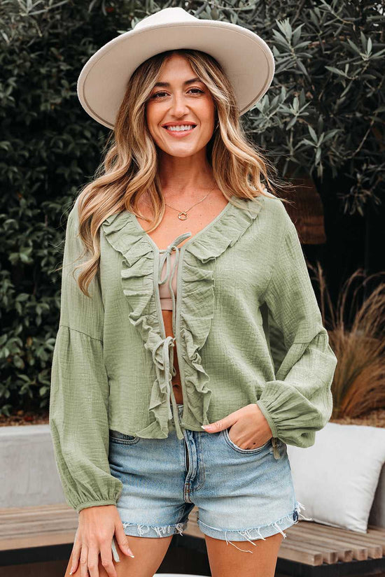 Front view of Meadow Cotton Blouse in soft green with ruffle details and tie closure, styled for a chic and breezy everyday outfit.