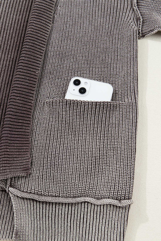 Detail of front pocket on brown stonewash patchwork knit open cardigan with smartphone inside, showcasing practical design for everyday use.