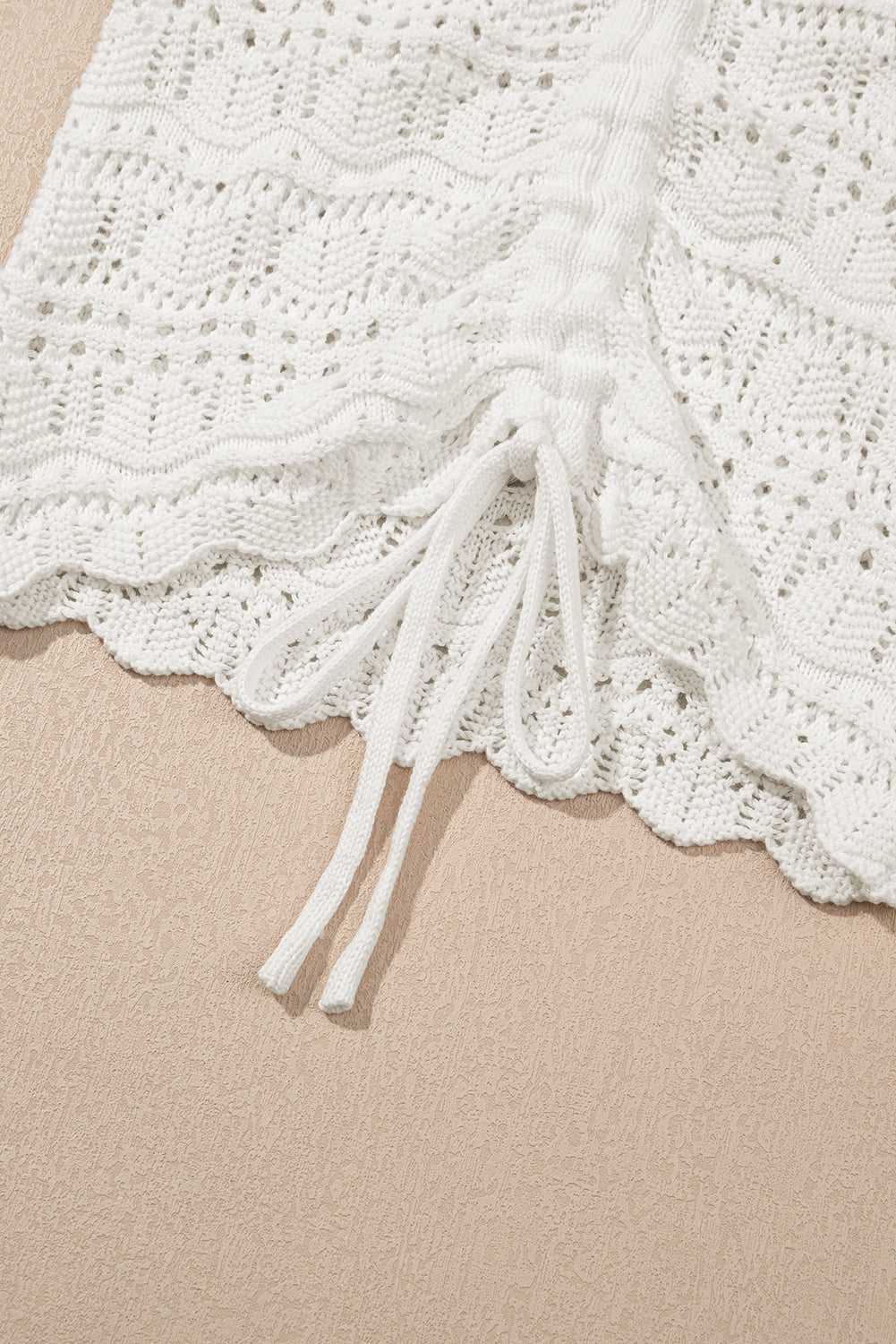 Detailed view of drawstring and scalloped edge on white crochet tank top, showcasing breathable and stylish summer design.