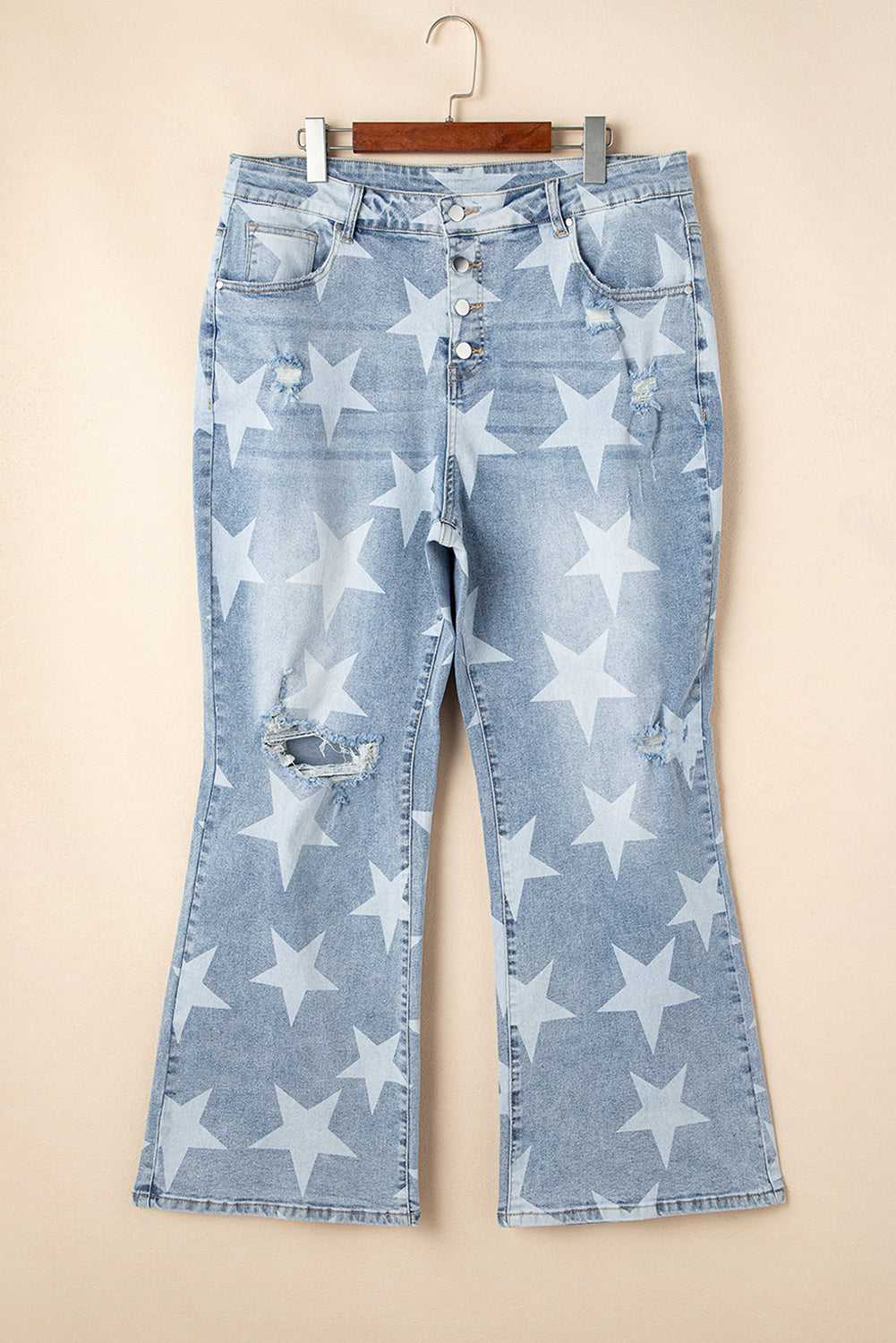 Flat lay of blue distressed plus size jeans with white star print and wide-leg cut, ideal for casual summer fashion collections.